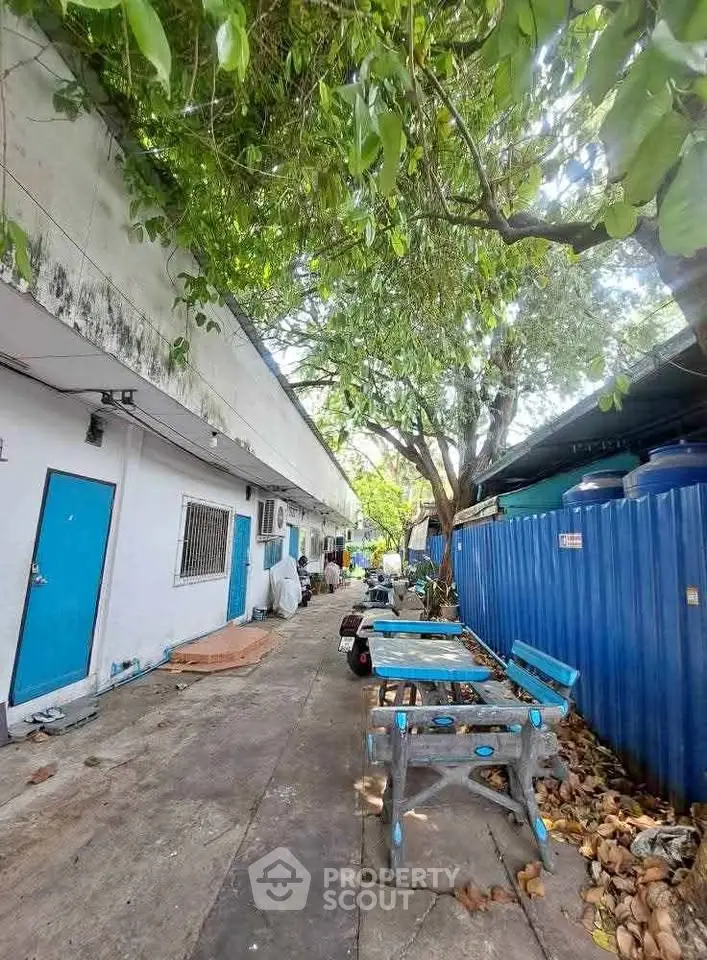 Charming outdoor area with rustic blue benches and lush greenery, perfect for relaxation and gatherings.