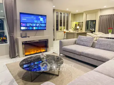 Luxurious modern living room with fireplace and smart TV, open layout to elegant kitchen.