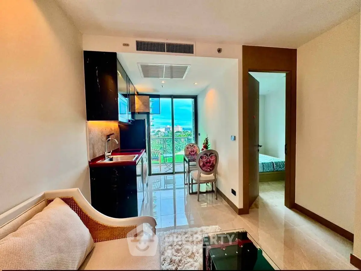 Modern apartment interior with open layout, featuring a cozy living area, compact kitchen, and balcony view.