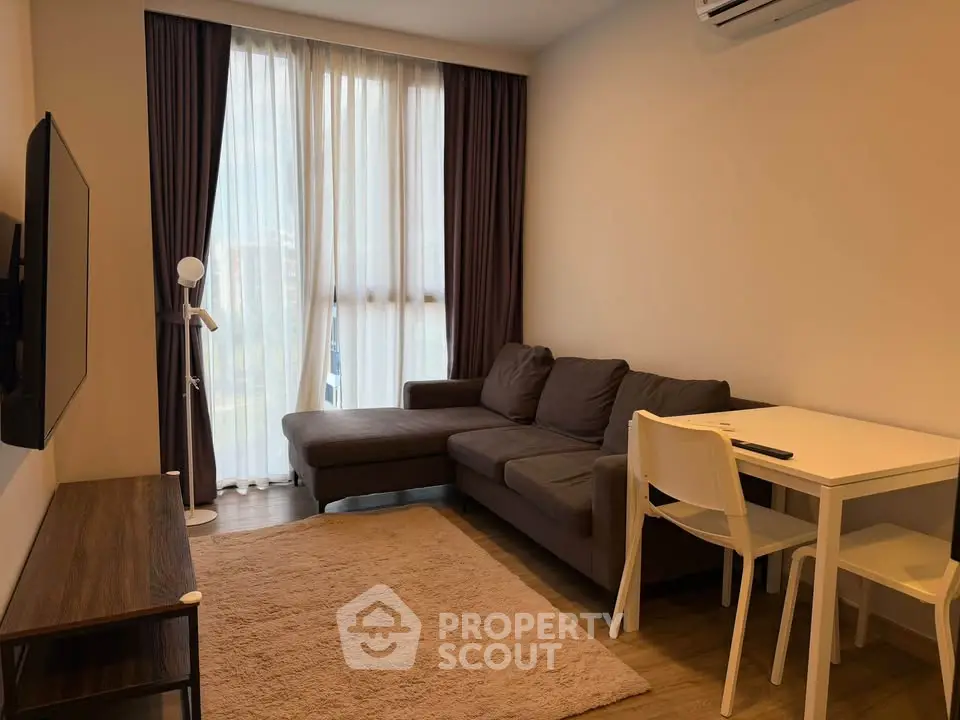 Cozy living room with modern sofa and wall-mounted TV, perfect for relaxation.