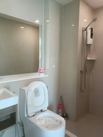 Modern bathroom with sleek shower and toilet in contemporary apartment.