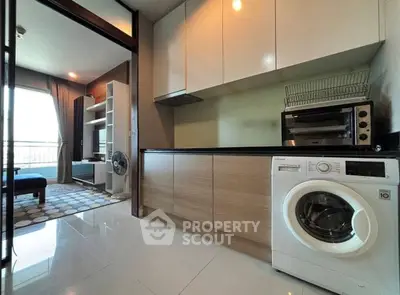 Modern kitchen with washing machine and sleek cabinetry in a stylish apartment