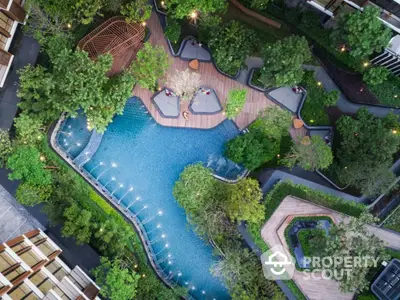 Stunning aerial view of luxurious residential pool surrounded by lush greenery and modern architecture.