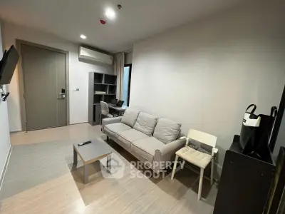 Modern living room with sleek furniture and neutral tones, featuring a cozy sofa and wall-mounted TV.