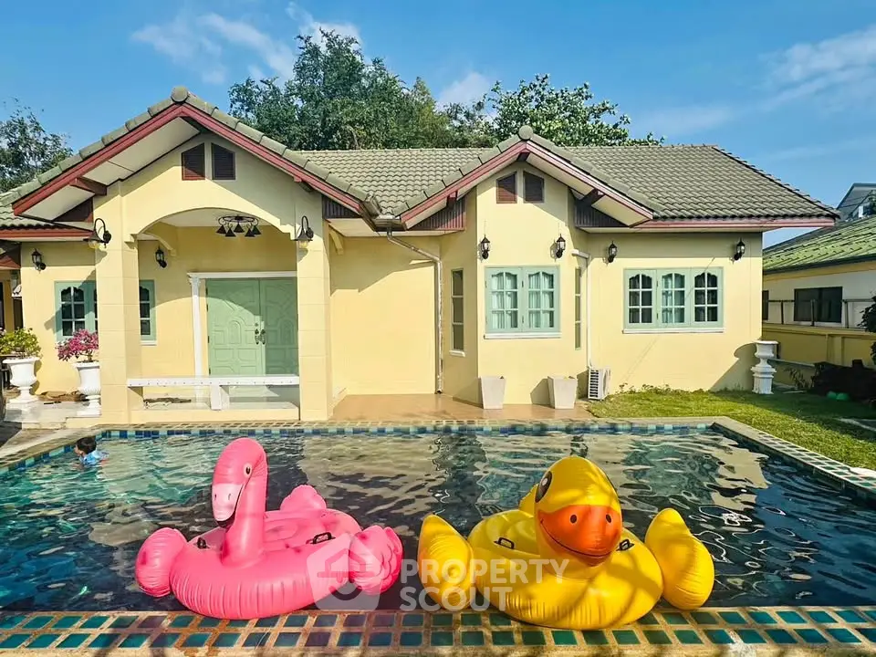 Charming house with inviting pool and playful inflatables, perfect for family relaxation.
