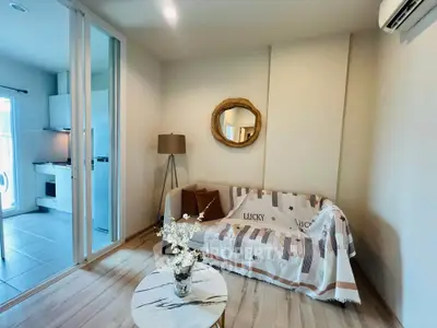 Charming living room with cozy decor and modern kitchen view, perfect for urban living.