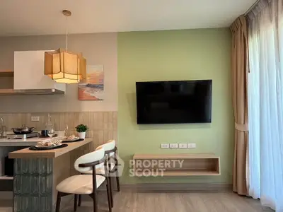 Modern kitchen and living area with stylish decor and wall-mounted TV in a cozy apartment.