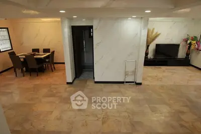 Spacious open-plan living and dining area with elegant marble flooring and modern decor.