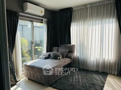 Cozy living room with plush seating and natural light through large windows