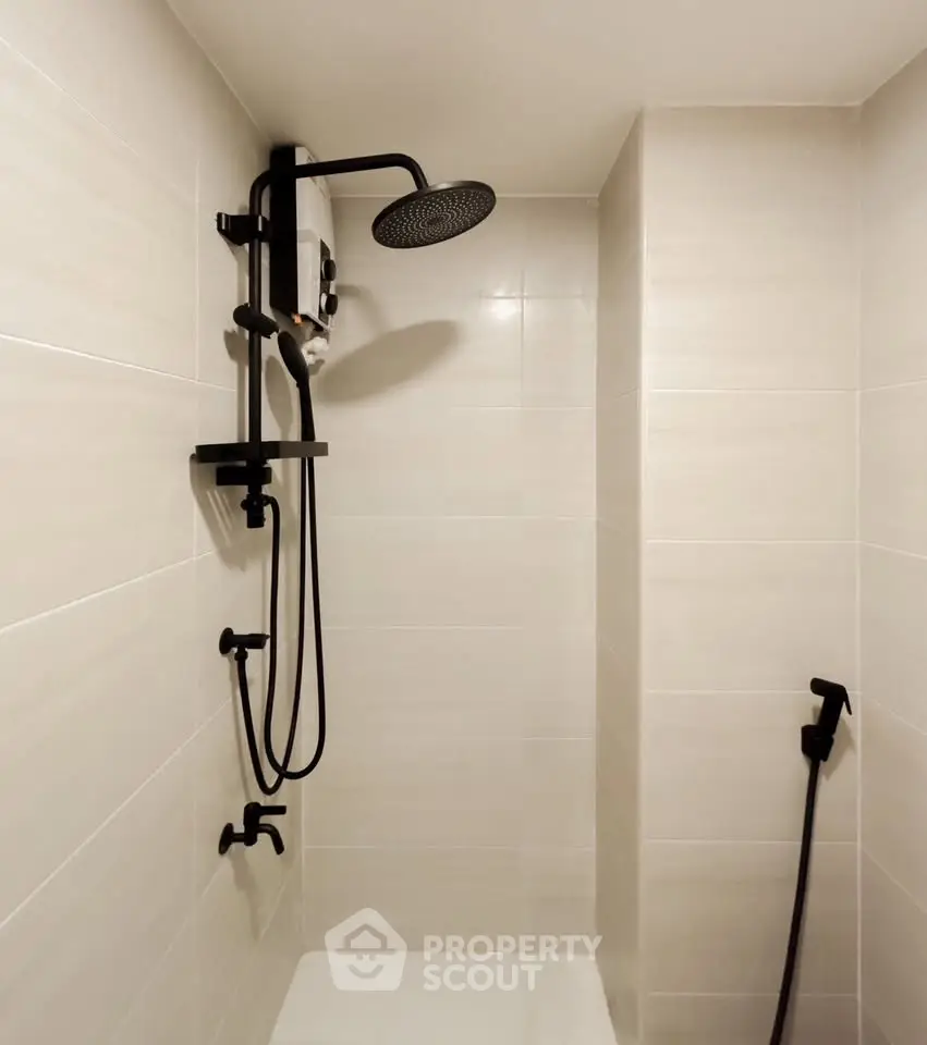 Modern bathroom with sleek shower fixtures and neutral tile design.