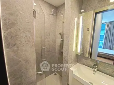 Modern bathroom with sleek shower and elegant sink in luxury apartment.