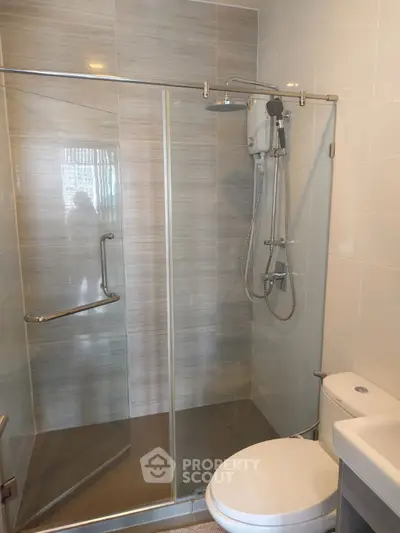 Modern bathroom with glass shower enclosure and sleek fixtures