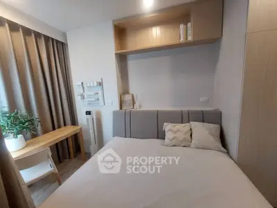 Cozy bedroom with modern decor and natural light, featuring a comfortable bed and stylish workspace.