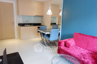 Modern living room with vibrant red sofa and stylish dining area in open layout.