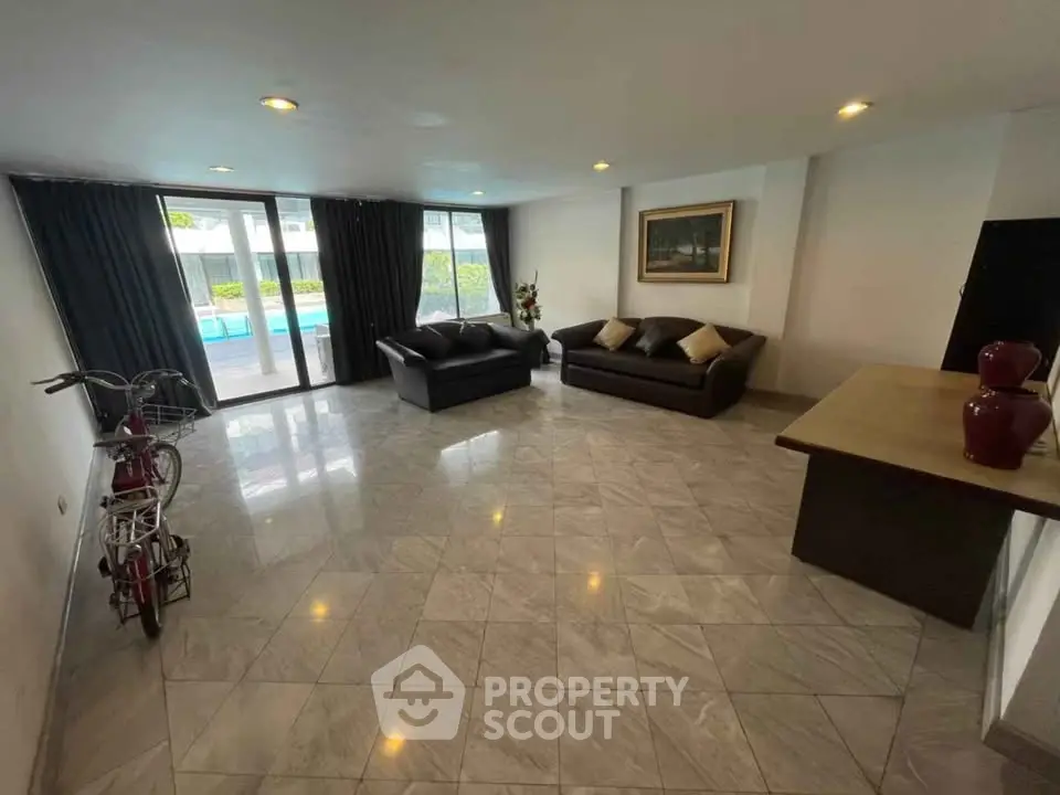 Spacious living room with pool view, modern sofas, and elegant decor in a luxury home.