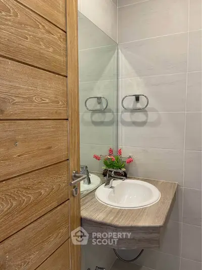 Modern bathroom with stylish wooden door and elegant sink design