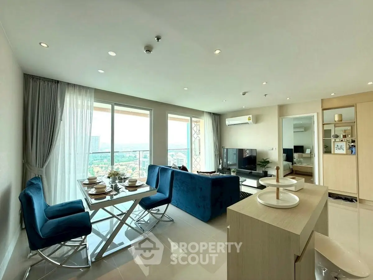 Luxurious open-plan living room with stunning city view, modern furniture, and elegant dining area.