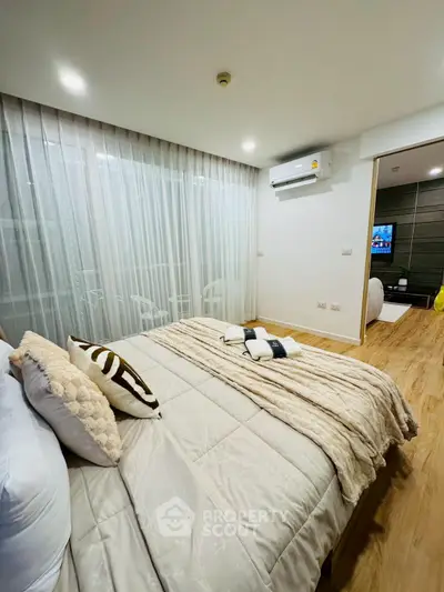 Modern bedroom with cozy decor and wooden flooring, featuring a comfortable bed and ambient lighting.