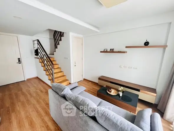 Modern living room with wooden flooring and stylish staircase