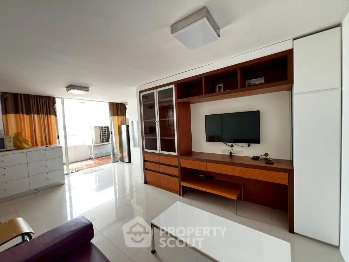 Spacious living room with modern entertainment center and large windows