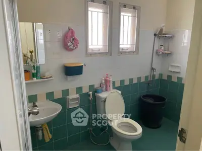 Spacious bathroom with modern fixtures and natural light from two windows.