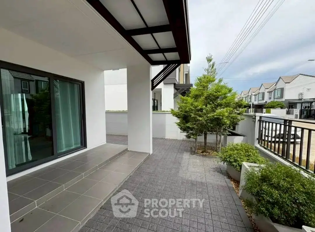 Modern townhouse exterior with spacious patio and lush greenery