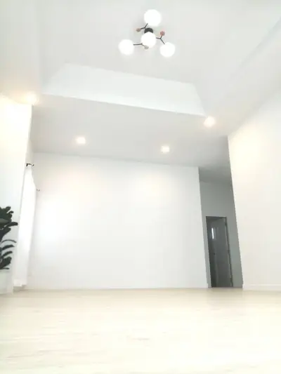 Spacious modern living room with high ceiling and elegant lighting