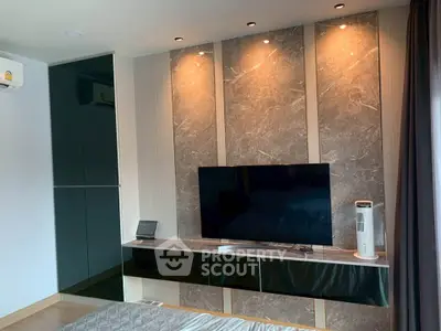 Modern bedroom with sleek TV setup and elegant lighting