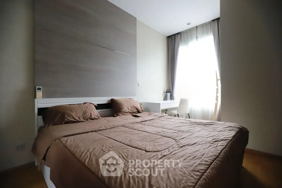 Cozy bedroom with modern decor and natural light from large window