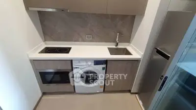 Modern compact kitchen with integrated appliances and sleek cabinetry