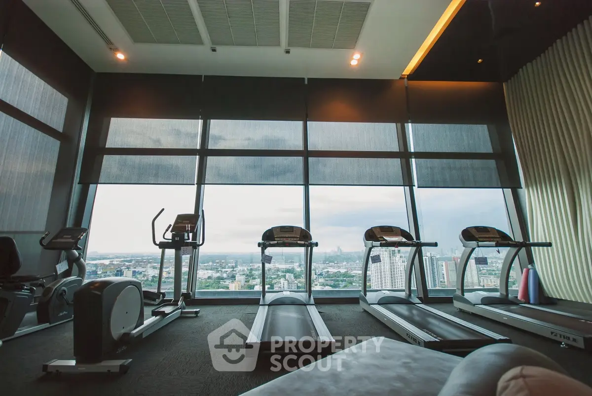 Luxurious high-rise gym with panoramic city views and modern fitness equipment.