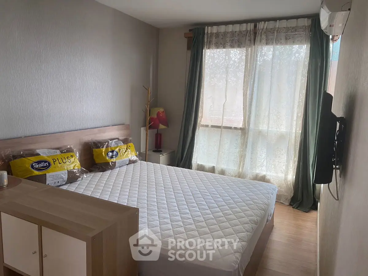 Cozy bedroom with natural light, modern decor, and comfortable bedding in a stylish apartment.