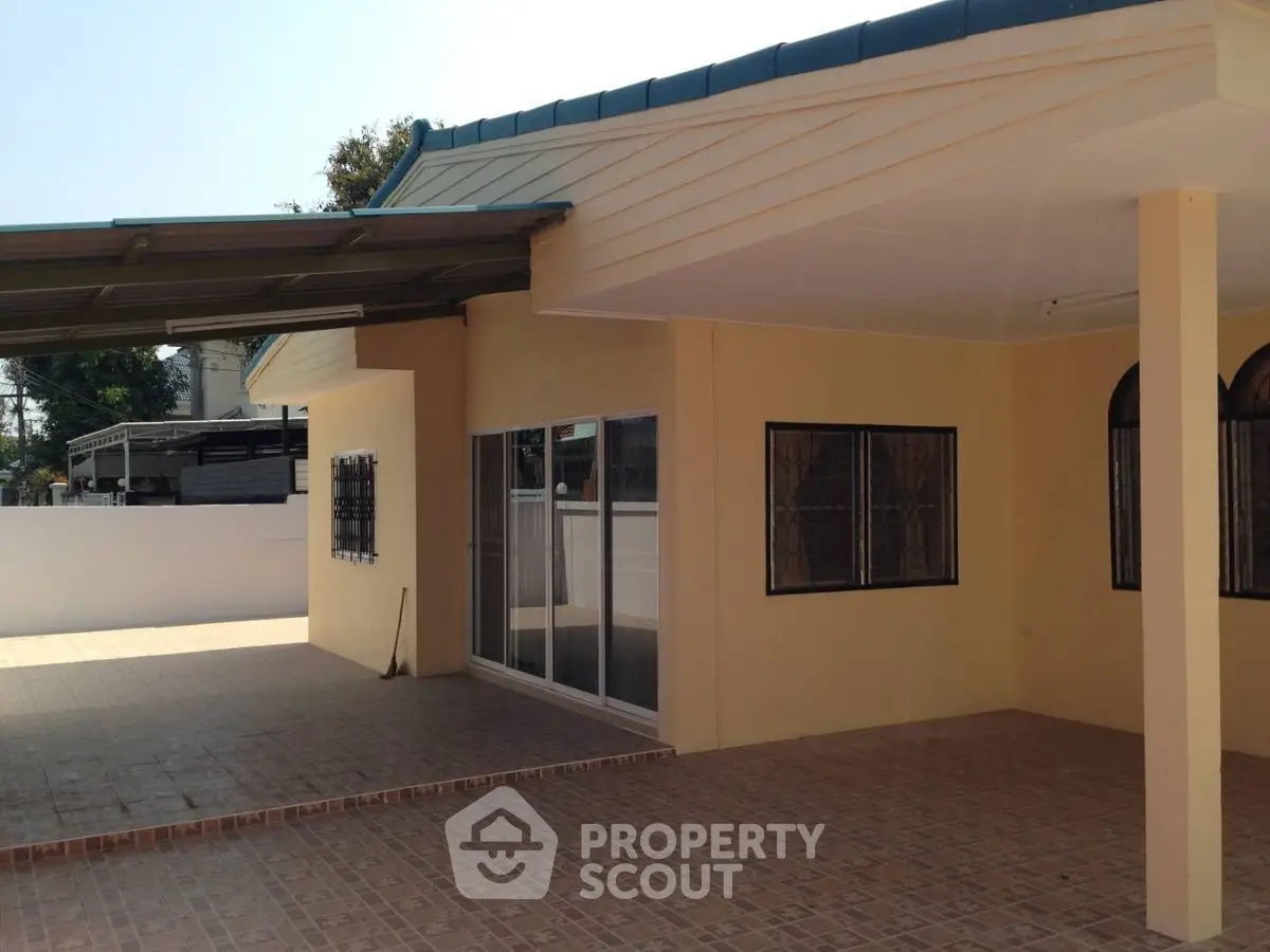 Spacious single-story home with large tiled patio and covered parking area.