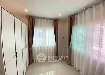 Bright and spacious bedroom with large windows and modern wardrobe