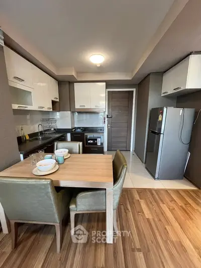 Modern kitchen with dining area, featuring sleek cabinets and stainless steel appliances.