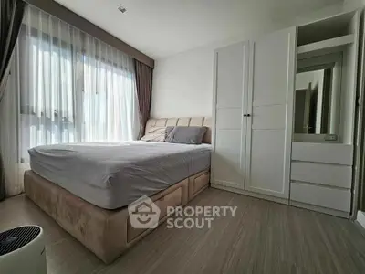 Spacious bedroom with modern decor and ample natural light, featuring a large bed and stylish wardrobe.