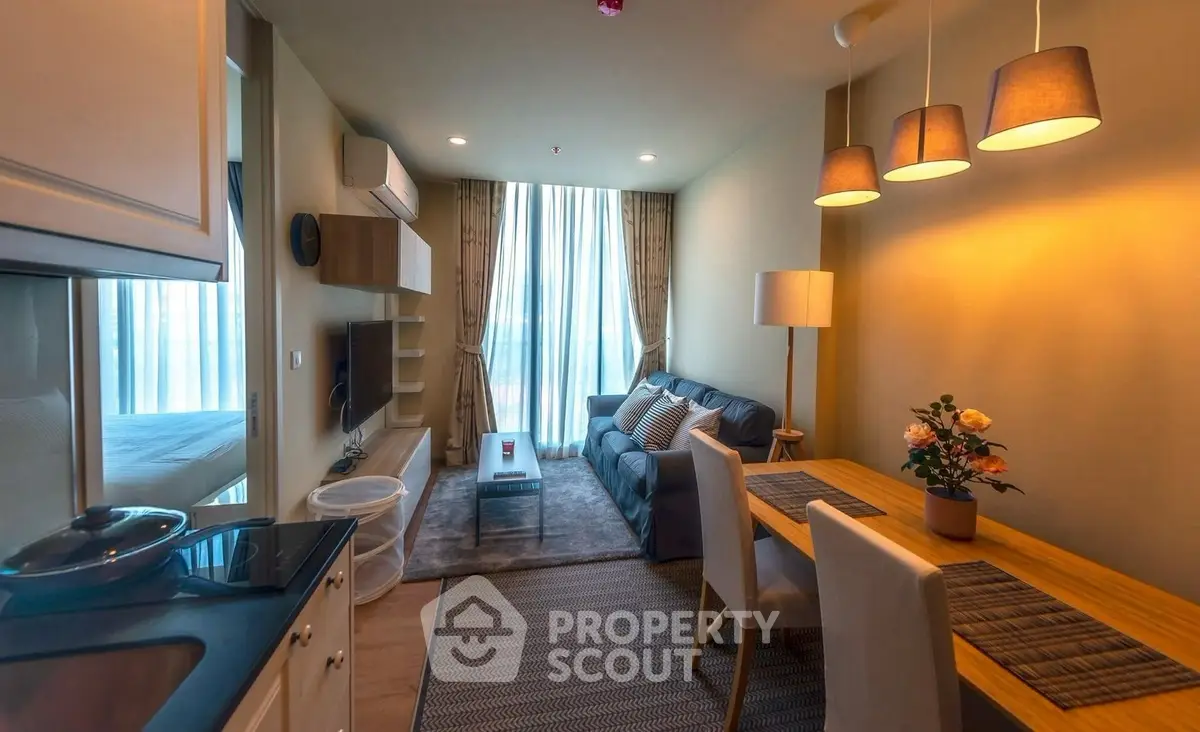 Modern living room with cozy seating and dining area, featuring stylish lighting and decor.