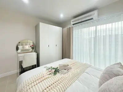 Cozy bedroom with modern decor, featuring a comfortable bed, wardrobe, and a stylish vanity area.
