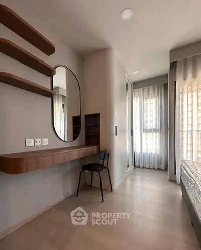 Modern bedroom with sleek design, featuring a stylish mirror and built-in wardrobe.