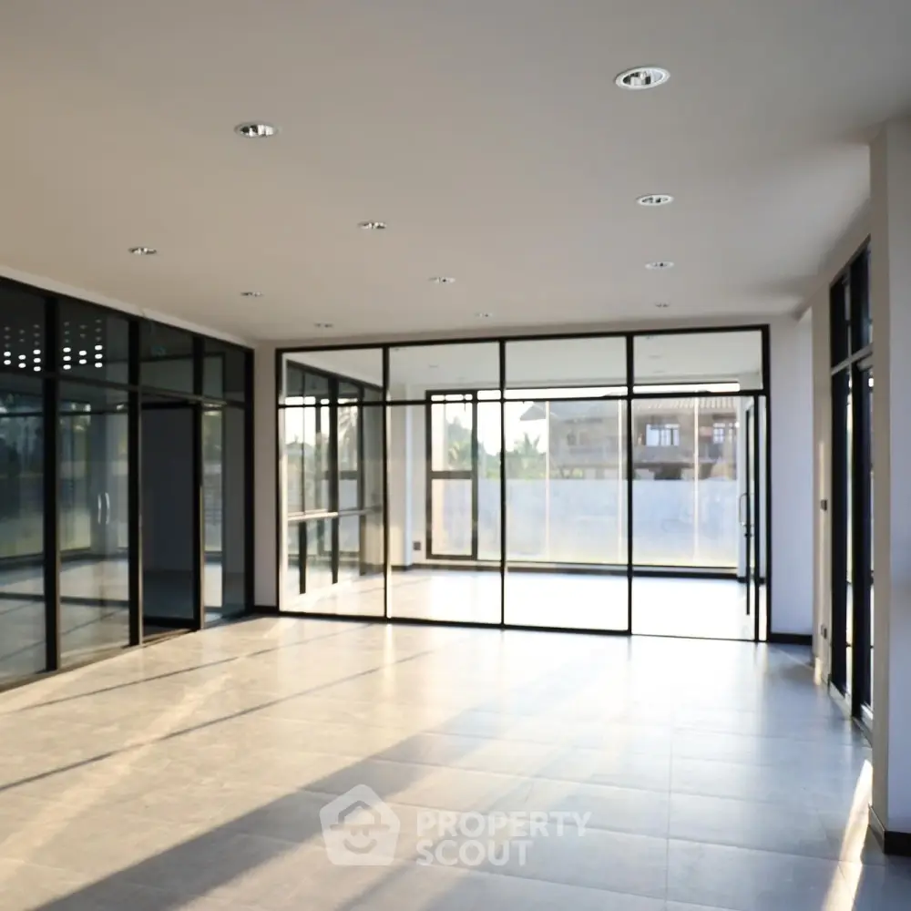 Spacious modern living room with large windows and abundant natural light