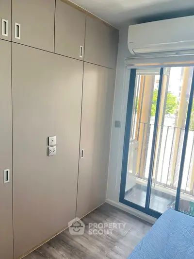 Modern bedroom with built-in wardrobe and balcony access