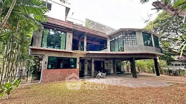 Stunning modern house with expansive windows and lush garden surroundings.