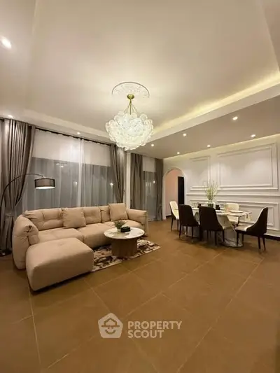 Luxurious living room with elegant chandelier and spacious dining area, perfect for modern living.