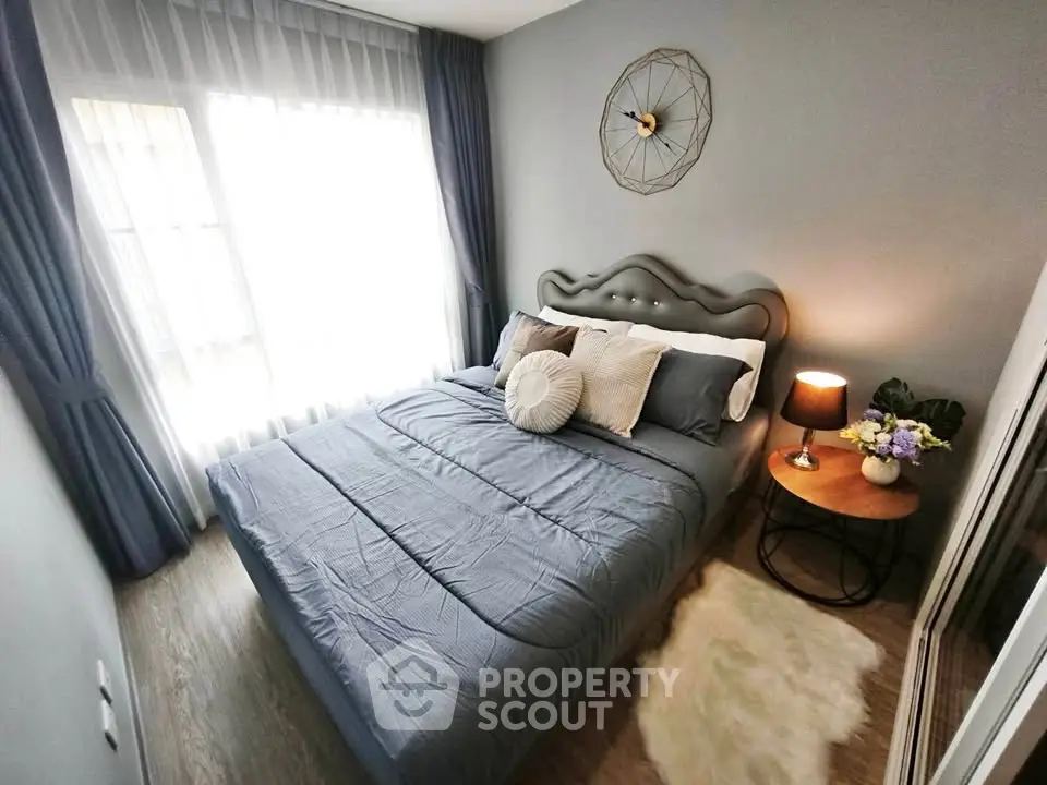 Cozy bedroom with stylish decor and natural light, featuring a plush bed and elegant side table.