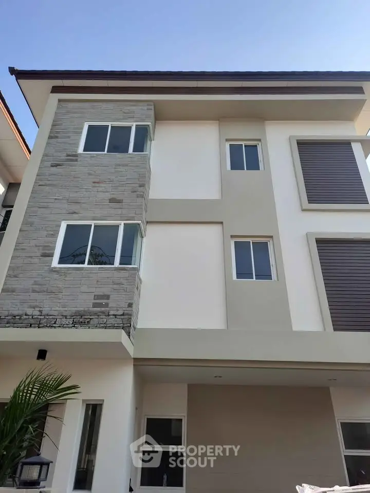 Modern three-story house with stylish facade and large windows