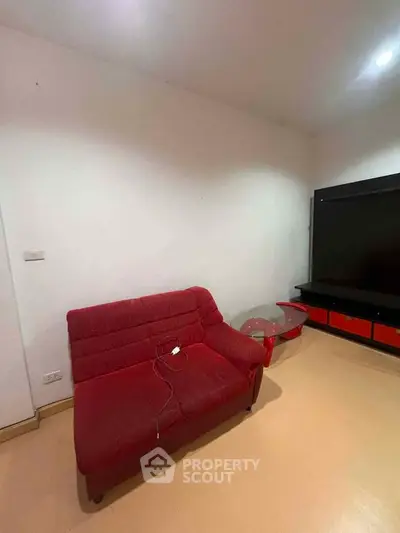 Cozy living room with red sofa and modern entertainment unit, perfect for relaxation.