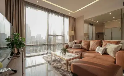 Luxurious living room with large windows and city view, featuring a stylish leather sofa and modern decor.