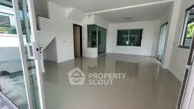Spacious modern living room with glossy tiled floors and large windows for natural light.
