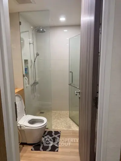 Modern bathroom with glass shower and wooden flooring