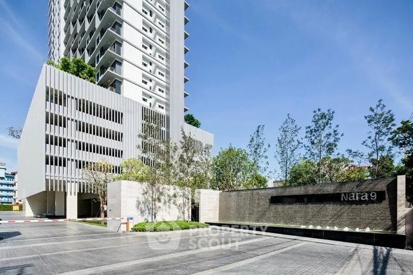 Modern high-rise building with sleek design and landscaped entrance at Nara 9.